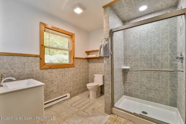 a bathroom with a shower a toilet and a sink