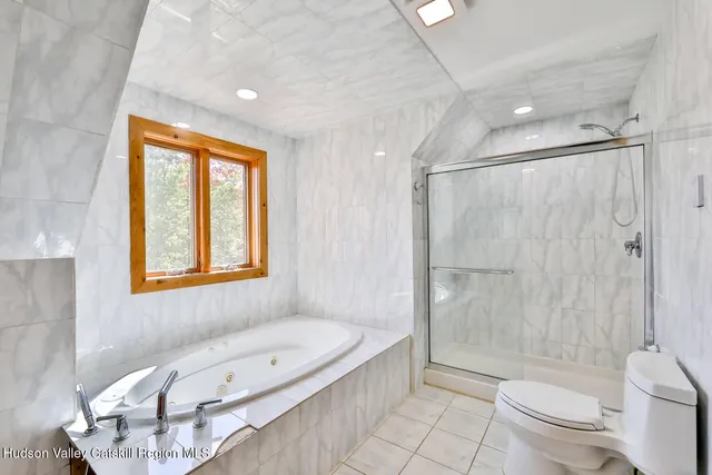 a bathroom with a bathtub toilet and shower