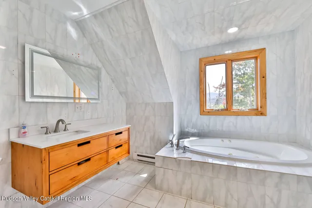 a bathroom with a sink a tub and mirror