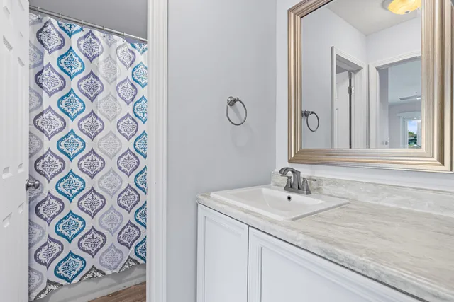 a bathroom with a granite countertop sink a toilet and a mirror