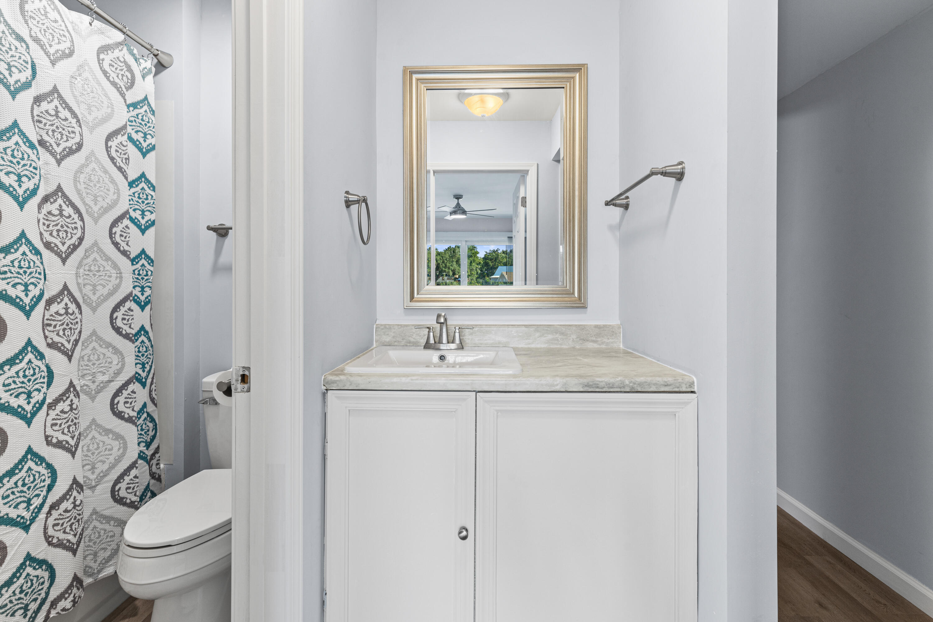 210 Pelham Road, Unit 109B Fort Walton Beach, FL 32547 - Photo 12 of 33 a bathroom with a granite countertop sink a toilet and a mirror