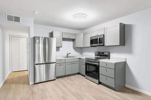 a kitchen with wooden cabinets and stainless steel appliances