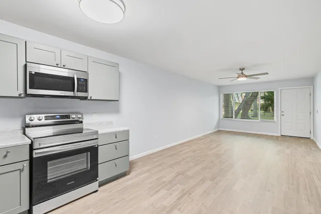 a kitchen with white cabinets stainless steel appliances and a sink