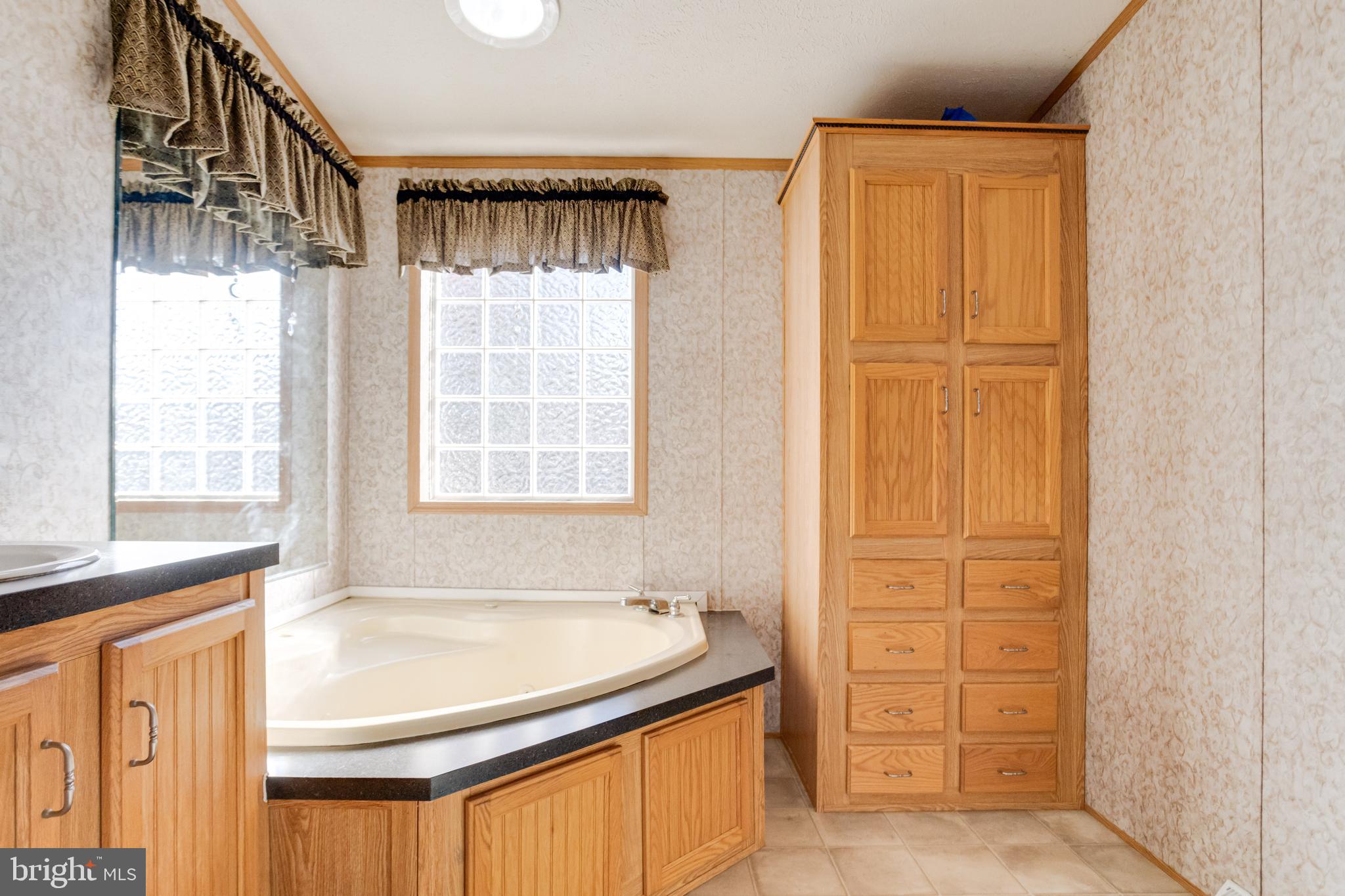 488 North Patuxent Road, Unit 18A Odenton, MD 21113 - Photo 22 of 34 a bathroom with a granite countertop sink and a bathtub