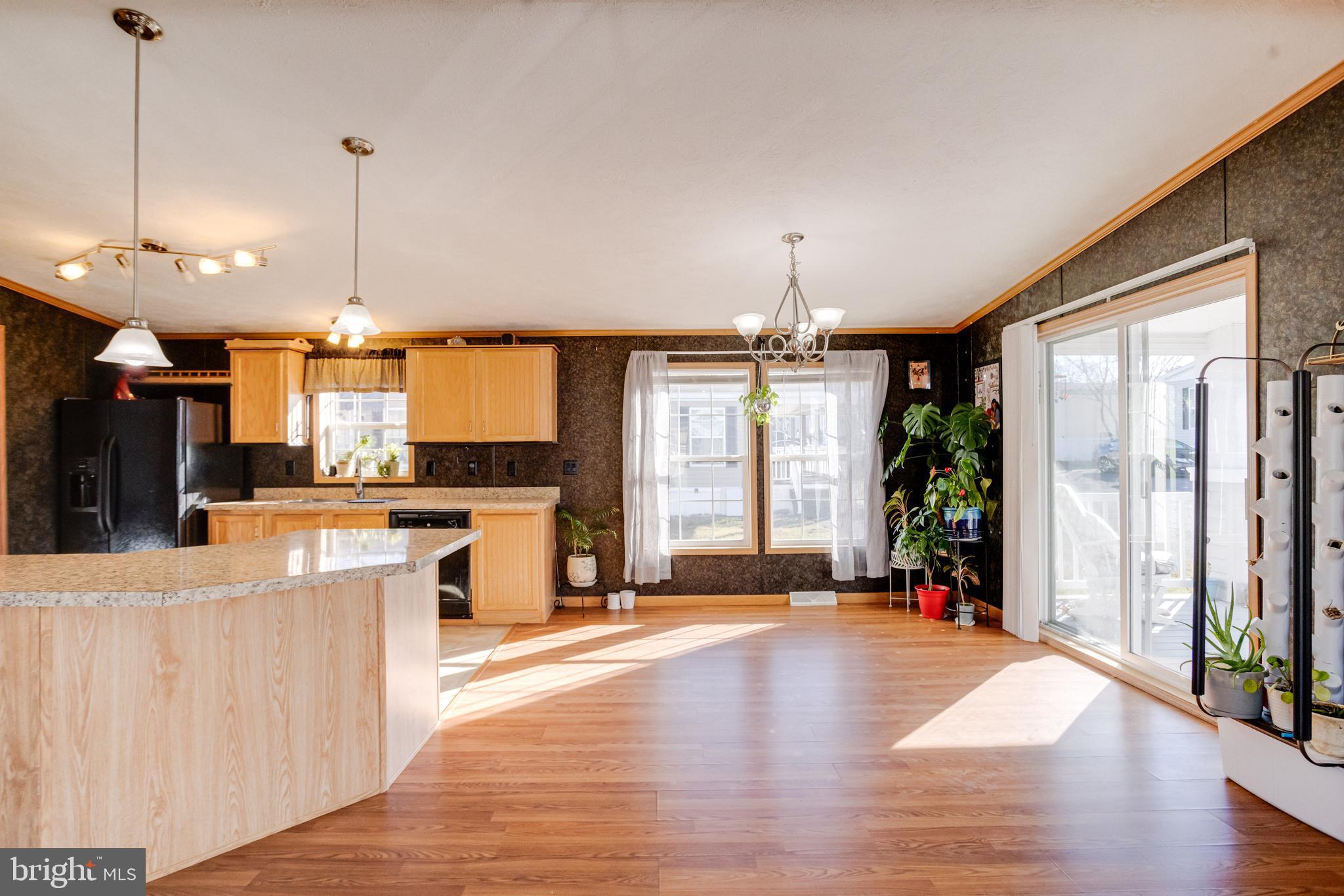 488 North Patuxent Road, Unit 18A Odenton, MD 21113 - Photo 9 of 34 a open kitchen with stainless steel appliances granite countertop a refrigerator a oven a dining table and chairs with wooden floor