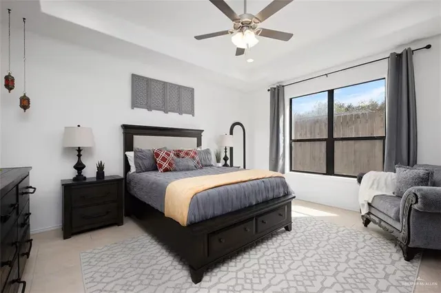 a bedroom with a bed a couch and a flat screen tv