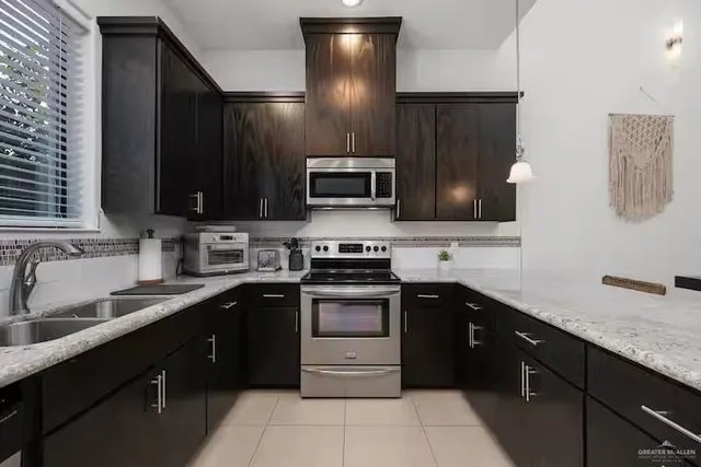 a kitchen with stainless steel appliances granite countertop a sink and a stove