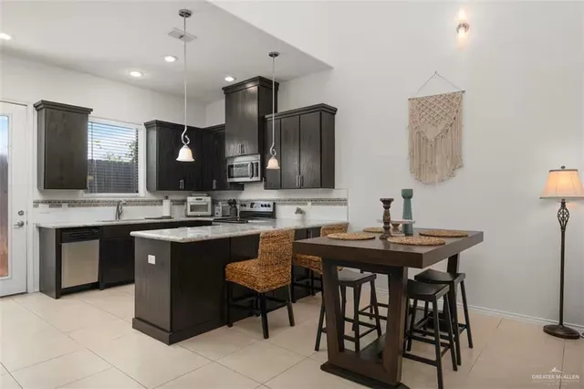 a kitchen with stainless steel appliances granite countertop a sink and a white cabinets