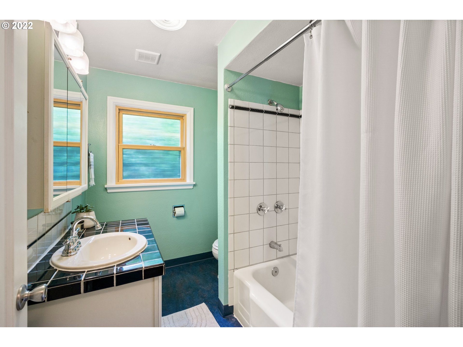 3286 Northeast Holman Street Portland, OR 97211 - Photo 17 of 25 a bathroom with a sink a mirror and a bathtub