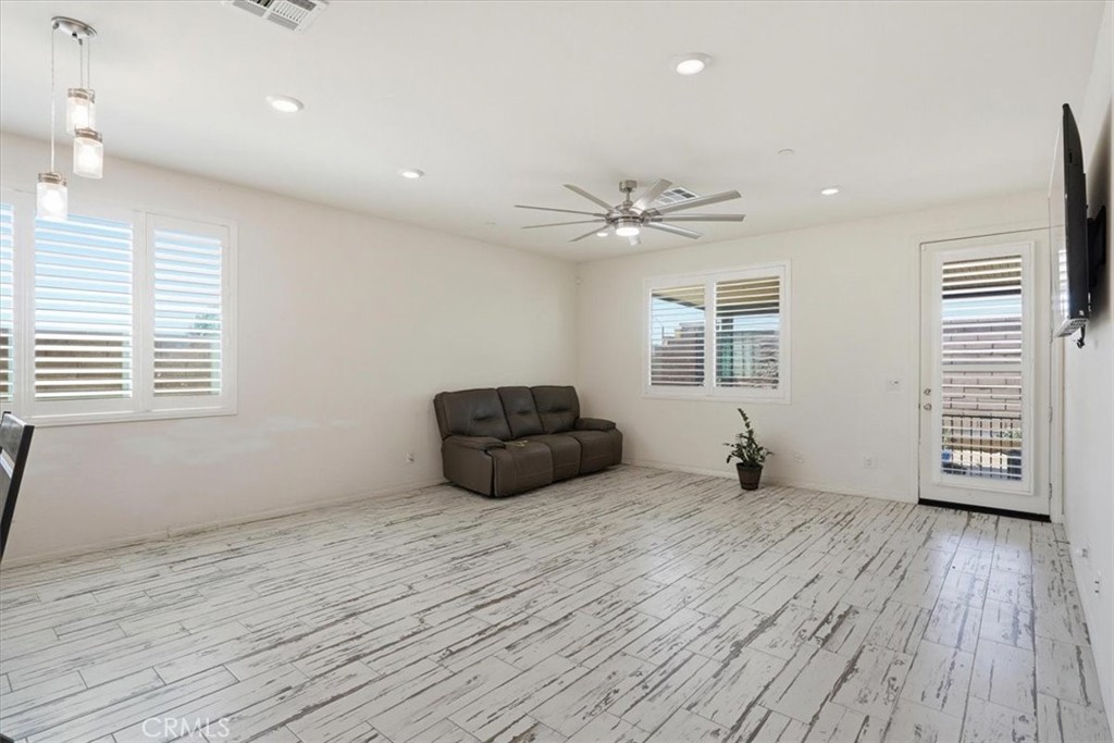 32350 Iron Trail Road Winchester, CA 92596 - Photo 6 of 32 a view of an empty room with a window and wooden floor
