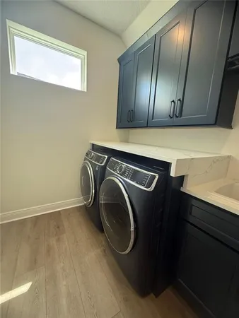a utility room with wooden floor washer and dryer