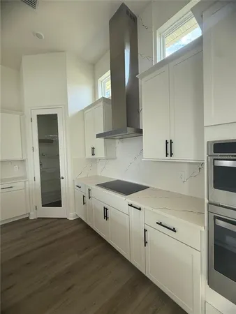 a kitchen with granite countertop white cabinets and white appliances