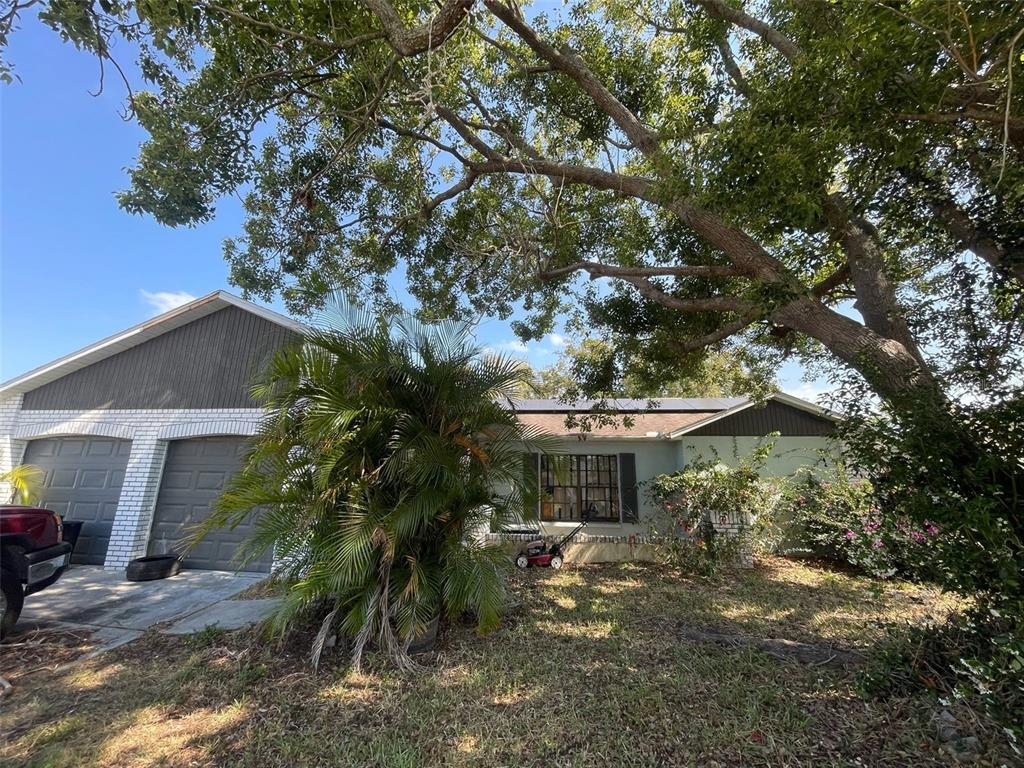 7421 Mulligan Court Port Richey, FL 34668 - Photo 1 of 1 a backyard of a house with table and chairs under an umbrella