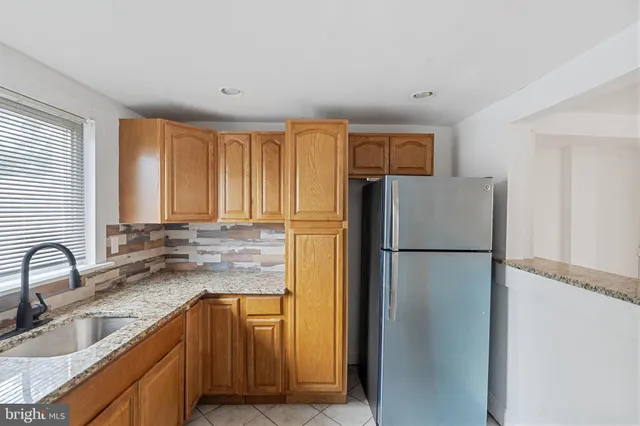 a kitchen with a refrigerator sink and cabinets
