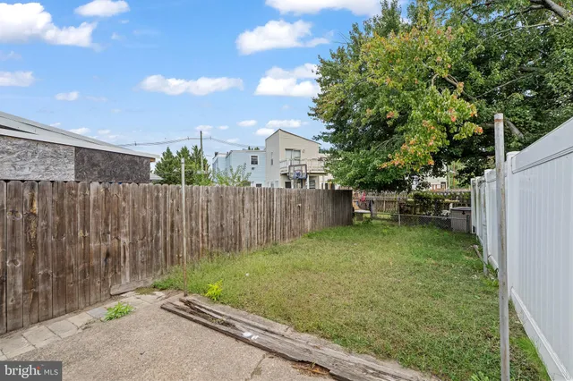 a backyard of a house with plants and tree