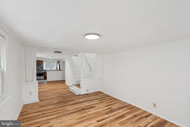 a view of a room with wooden floor and a kitchen