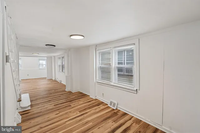 a view of a livingroom with wooden floor and a window
