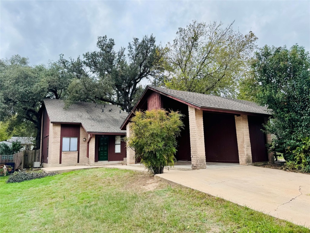 a front view of a house with yard and trees