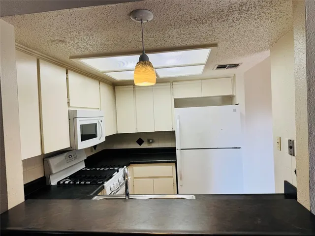 a kitchen with a refrigerator a stove a microwave and wooden floor