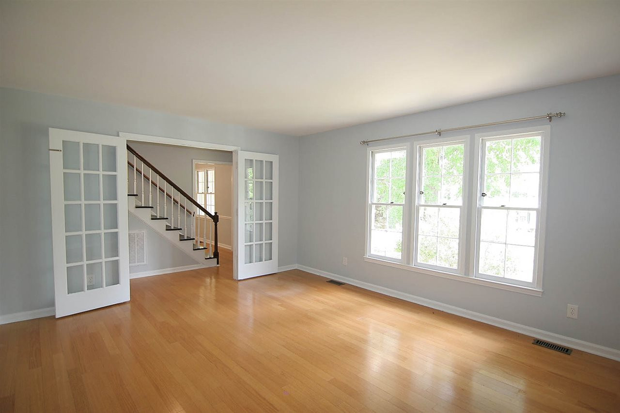 7801 Audubon Drive Raleigh, NC 27615 - Photo 5 of 25 Spacious Living Room will Charm Your Socks Off. Classic French Doors at Entry and Bank of Windows to let the Sunshine In. Hardwood Floors for Warmth. Prewired for Speakers Living Room
