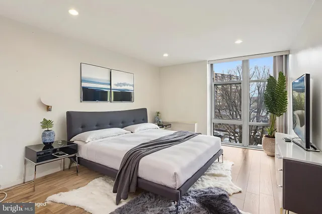 a bedroom with a large bed and a flat screen tv