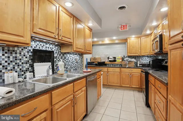 a kitchen with stainless steel appliances granite countertop a sink and cabinets