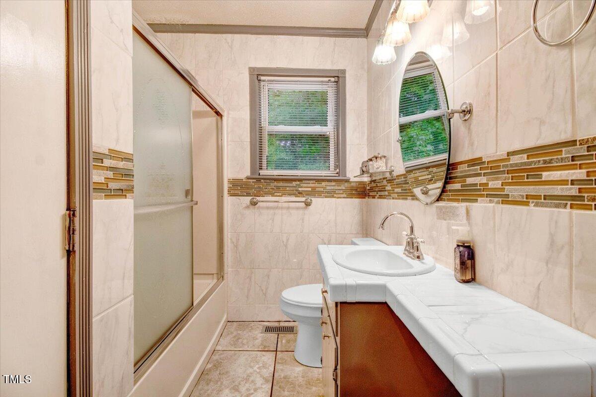 607 East Geer Street Durham, NC 27701 - Photo 16 of 23 a bathroom with a sink a toilet and a mirror