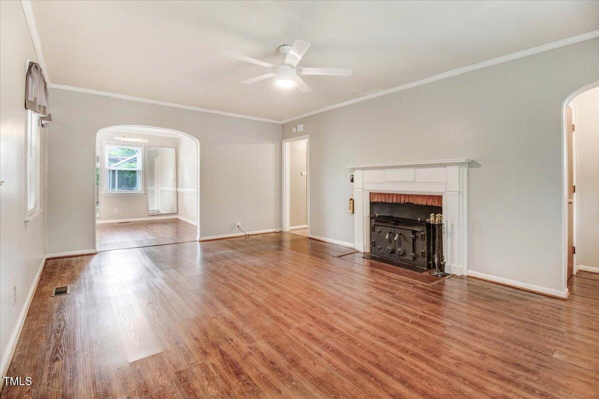 607 East Geer Street Durham, NC 27701 - Photo 7 of 23 an empty room with wooden floor fireplace and windows