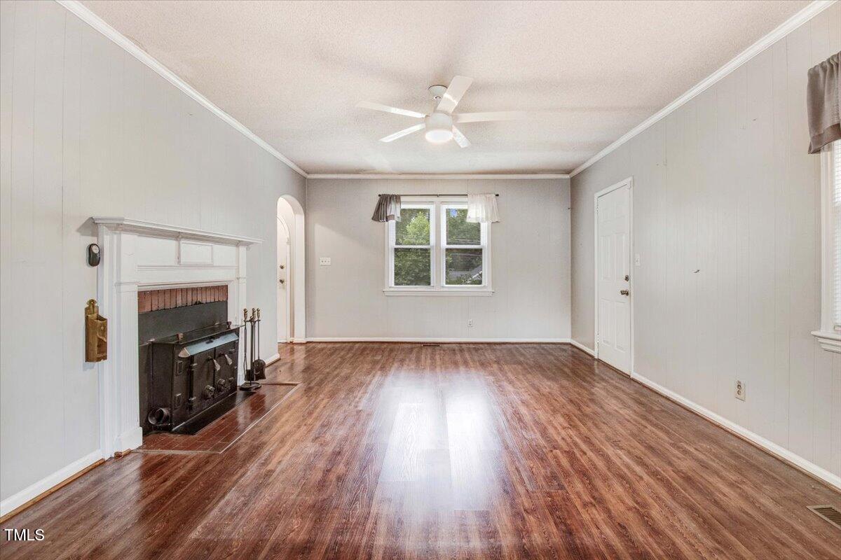 607 East Geer Street Durham, NC 27701 - Photo 8 of 23 an empty room with wooden floor fireplace and windows