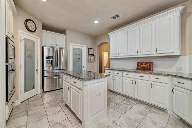 a kitchen with stainless steel appliances granite countertop a refrigerator and a stove top oven