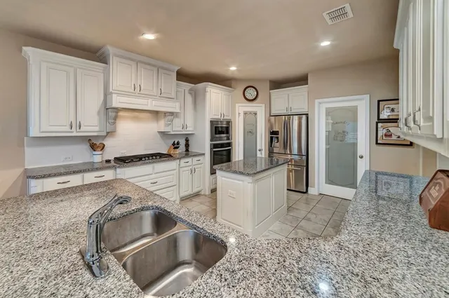 a kitchen with granite countertop a sink and a stove top oven