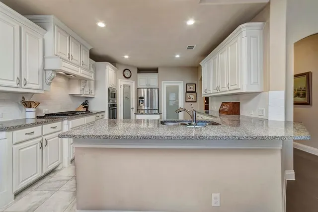 a kitchen with stainless steel appliances granite countertop refrigerator sink and cabinets