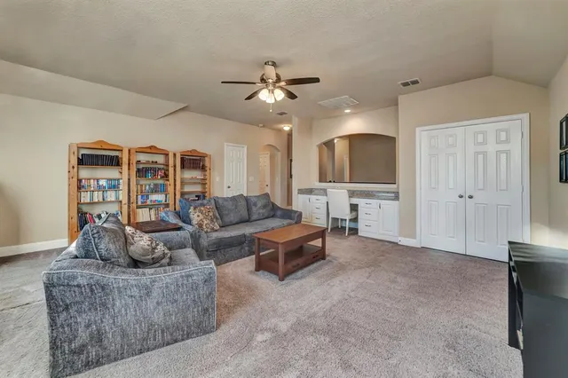 a living room with furniture and a ceiling fan
