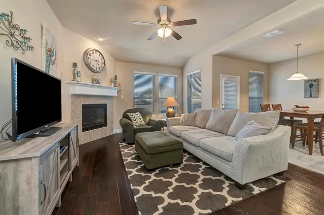 a living room with furniture a flat screen tv and a fireplace