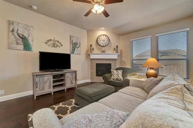 a living room with furniture a flat screen tv and a fireplace