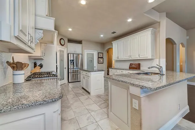 a kitchen with stainless steel appliances granite countertop a sink stove and cabinets