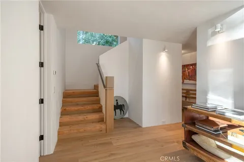 a view of a livingroom with wooden floor and stairs