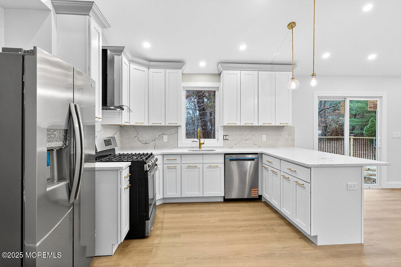 a kitchen with stainless steel appliances granite countertop a refrigerator a sink a stove and a oven