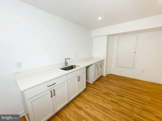 a kitchen with white cabinets and sink