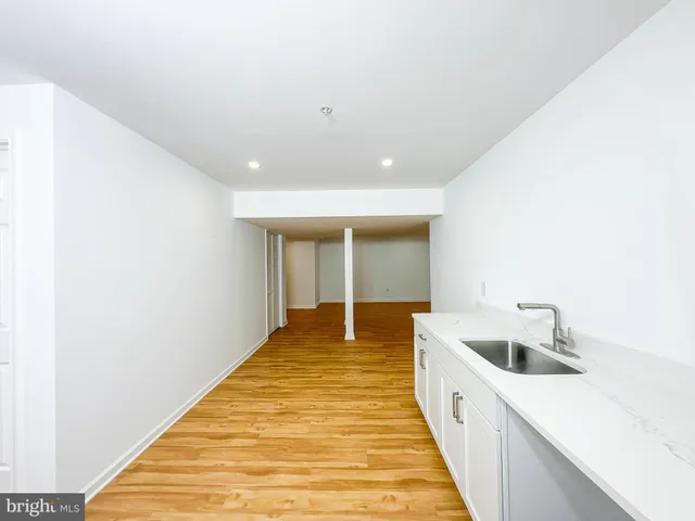 a view of a kitchen with a sink and wooden floor