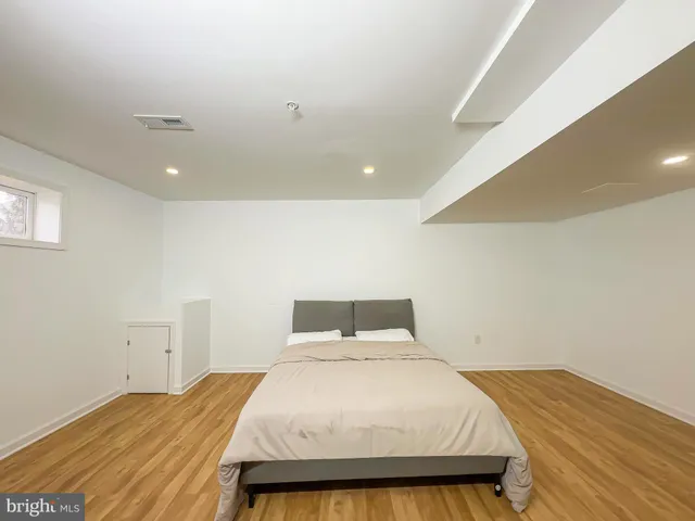 a bedroom with a bed and wooden floor