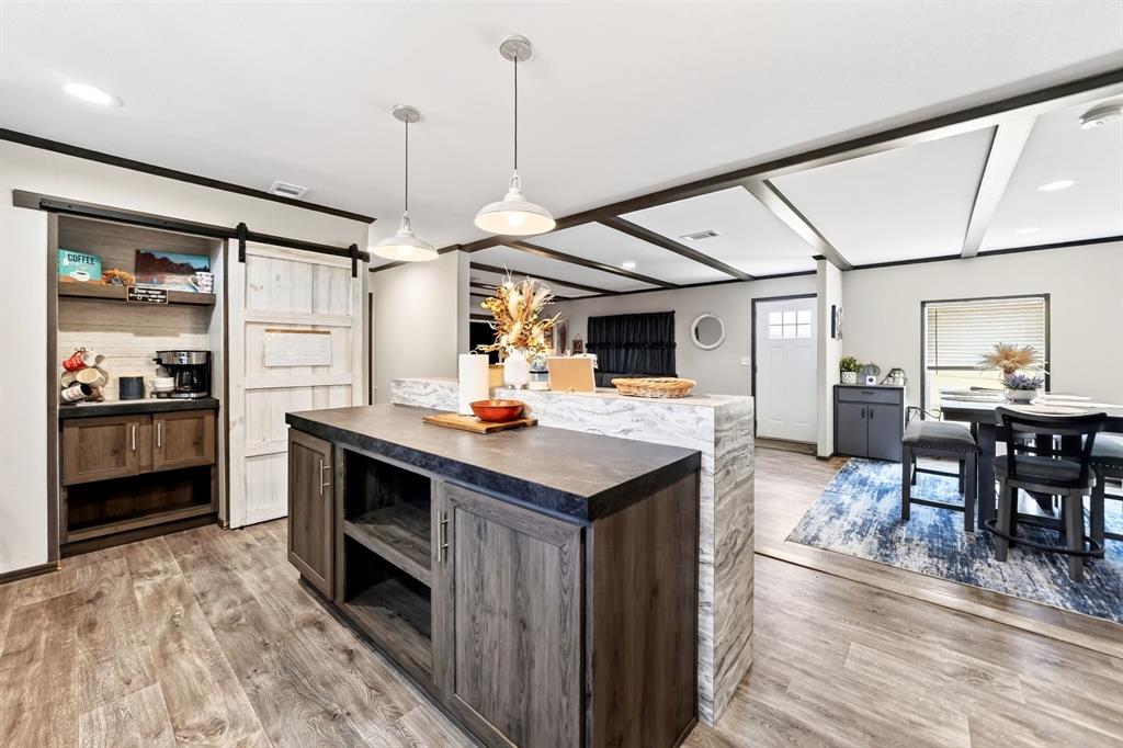 660 VZ County Road Canton, TX 75103 - Photo 26 of 39 Open-concept living space with wood-finish flooring, a kitchen island with integrated storage, and exposed beam ceiling details