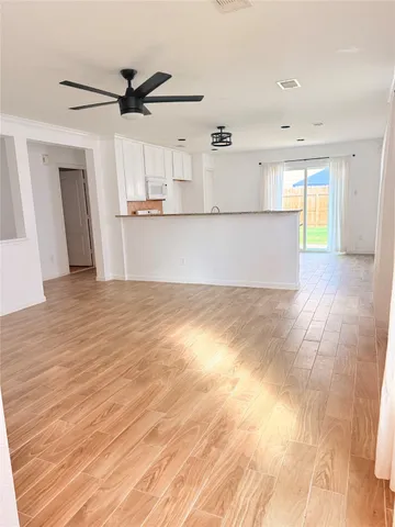 a view of empty room with wooden floor and window
