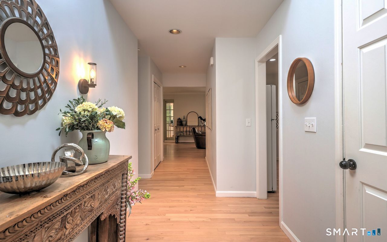 9 Canterbury Road, Unit 9 Hamden, CT 06514 - Photo 6 of 29 a hallway with painting on the wall and a mirror