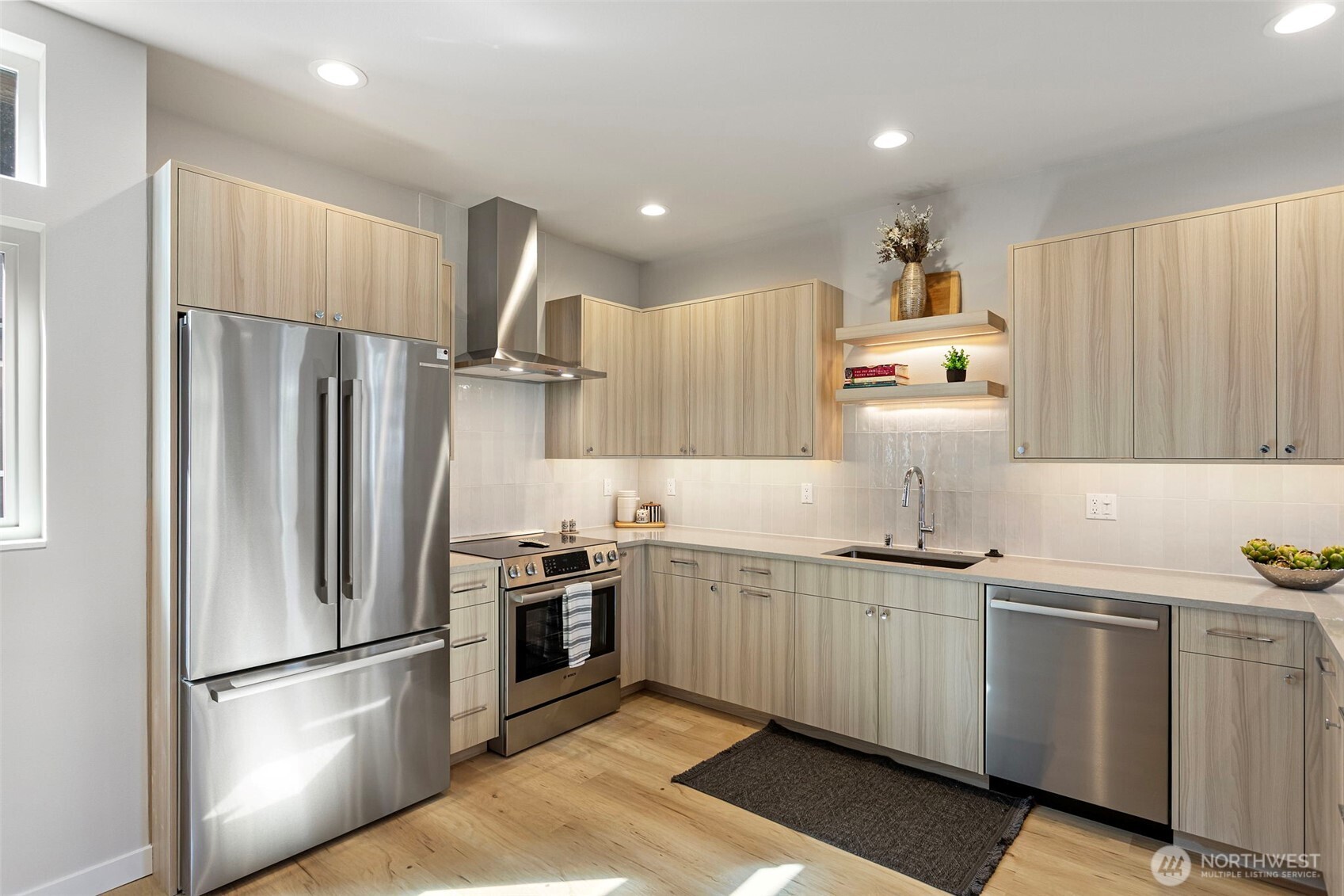 1127 Northwest 58th Street, Unit B Seattle, WA 98107 - Photo 11 of 30 a kitchen with kitchen island a sink stainless steel appliances and cabinets