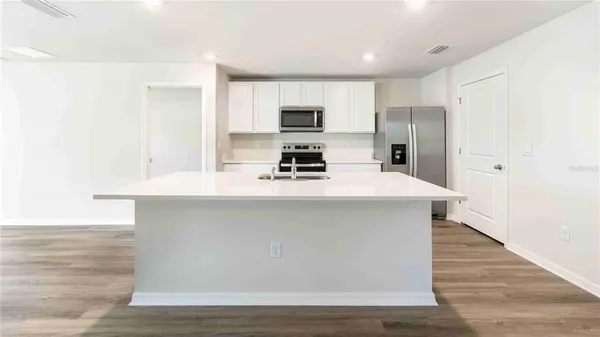 a kitchen with stainless steel appliances a refrigerator stove and microwave