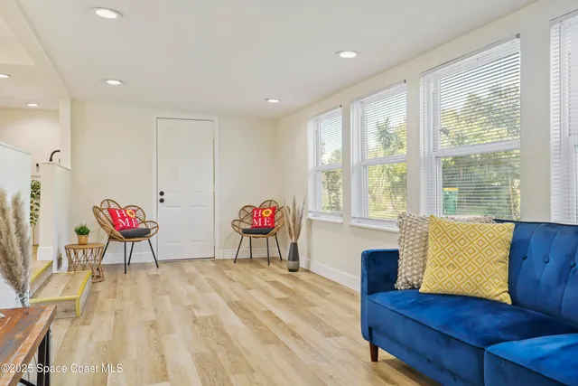 a living room with furniture and a wooden floor