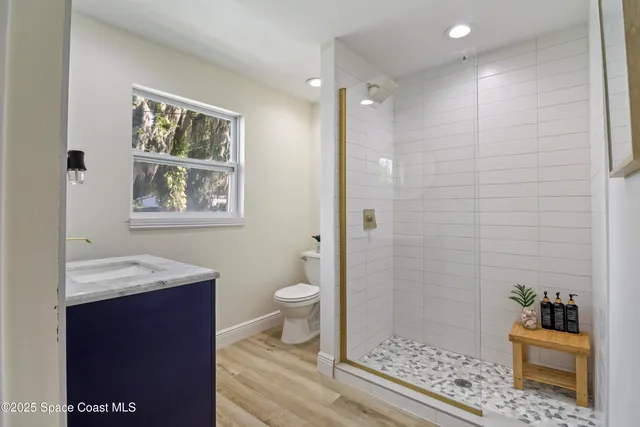 a bathroom with a sink a toilet and shower