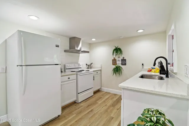 a kitchen with stainless steel appliances a refrigerator sink and white cabinets
