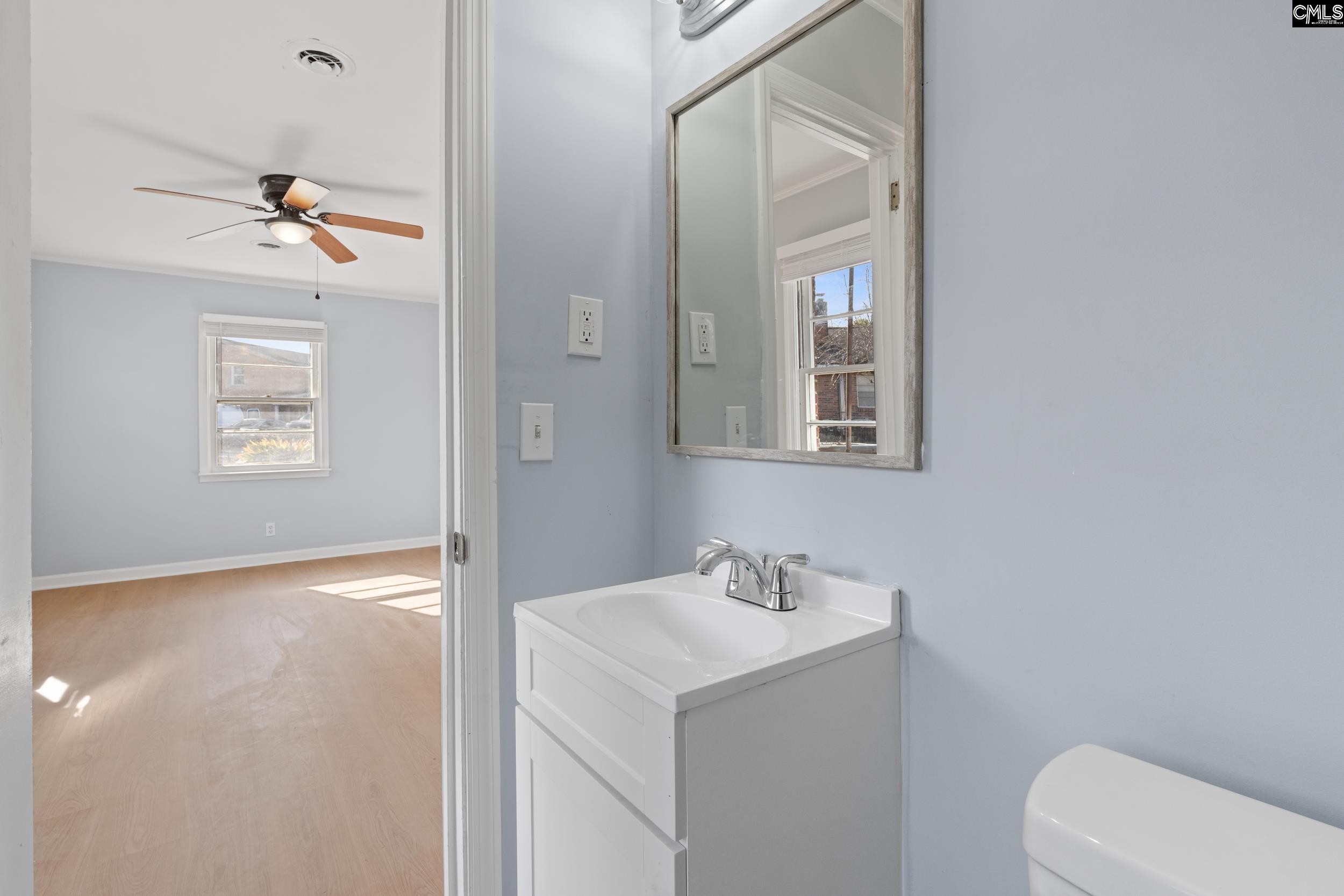 409 Wilkes Road Columbia, SC 29203 - Photo 24 of 34 a bathroom with a sink a toilet and mirror